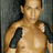 A pixelated static image shows a shirtless person with light skin tone standing against a dark gray background, wearing black shoulder straps.