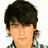 Pixelated close-up of a person with dark tousled hair, light skin tone, and closed eyes wearing a checkered shirt against white background.
