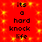 Red background with yellow sparkles and repeated black text reading 'its a hard knock life' in two