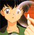 Pixelated cartoon character with light skin, large eyes, and a small red mouth, wearing an orange top and green bottom, holding a brown object against a dark background.