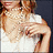A woman with light brown hair wears a white sleeveless top and multiple strands of pearls, posing in three distinct views.