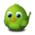 Green pixelated bird with large blue eyes, orange beak, and small tail on gray background.