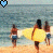 Pixelated beach scene with three figures walking toward water, two holding yellow surfboards, blue and red heart icons above.