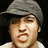 A pixelated image of a person wearing a gray cap and light-colored shirt against dark background, with text on the right side.