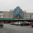 Pixelated static image showing a blurred urban scene with a prominent blue-tinted building structure and indistinct vehicles below.