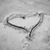 A grayscale pixelated icon depicting a stylized heart shape with a curved line extending from its lower right, set against a light gray background.