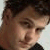 Pixelated close-up of a person's face with dark hair, light skin, and visible facial features including eyes, nose, and mouth.