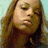 A pixelated image of a person with long brown hair against a light blue background, featuring text at the bottom.
