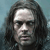 Pixelated close-up of a person with long dark hair against a muted blue background, showing facial features and hair texture in low-resolution.