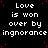 Black background with white pixelated text repeating 'Love is won over by ignorance' in a pattern, scattered red dots, and one gray square