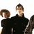 Animated contact sheet showing four distinct frames of a band with members in dark clothing against white backgrounds, arranged in 2x2 grid layout.