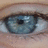 A close-up of a human eye with light blue iris and visible eyelashes, next to pixelated text reading 'blue eyed babe' on black background.