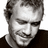Black-and-white pixelated image of a person with short curly hair wearing a dark shirt, shown in three distinct poses across a