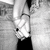 A grayscale pixelated image shows a hand holding a glass with liquid, set against an indistinct background.