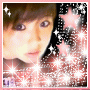 A pixelated image of a person with brown hair and purple eyes, surrounded by pink stars and white sparkles against a dark background.