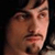Static close-up of a man's face with pixelated rendering and dark background, likely from a movie or character reference.