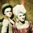 Two pixelated figures in historical attire stand side-by-side against a muted background, with pink text reading "People marching to the drums..." on the right.