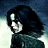 Pixelated figure with dark hair and light eyes against a blue and white gradient background, wearing a dark green outfit with visible shoulder and arm details.