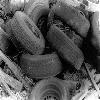 Black-and-white static icon featuring multiple overlapping cylindrical objects with visible text, set against a textured background.