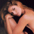 Static pixelated image of a person with light brown hair and a black choker, cropped to show upper body against dark background.