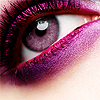 Close-up of a human eye with purple eyeshadow, long dark eyelashes, and a visible reflection in the pupil.