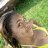 Pixelated image of a person with dark hair and light skin, wearing a yellow top, against a green background with yellow accents.