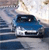 Pixelated static image of a blue car with white accents on a blurred background, viewed from a low angle.