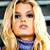 Static pixelated image of a person with long blonde hair wearing a blue top, visible against a blurred background.