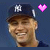 A baseball player wearing a dark blue cap with white NY logo, smiling face partially obscured by animated stars and pink hearts on a dark background.
