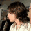 A woman with brown hair in a white lace top appears in four showing her head turning from left to right