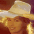 Static 50x50 pixel icon showing a person wearing a light-colored cowboy hat with a wide brim, long blonde hair visible beneath the hat, and warm-toned skin against a brownish background.