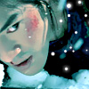 Pixelated close-up of a character with teal hair, rosy cheeks, and a faint smile against a starry background.