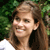 Static 50x50 pixel icon showing a smiling woman with brown hair against green foliage background, rendered in low-resolution pixel art style.