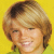 Static pixelated image of a person with light brown hair against a solid yellow background, wearing a green top.