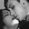 Black-and-white close-up of two people kissing, one with a visible ear piercing, both with dark hair, in a grainy, low-resolution style.