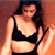 Pixelated image of a person wearing a black bralette and dark bottoms, standing against a warm-toned gradient background.