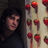 A static image with a green background, featuring pixelated red text and a small photo of strawberries on the left.
