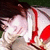 A pixelated image shows a person with light skin and dark hair wearing a white shirt and red tie, holding a red object against a blurred background.
