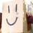 Animated image shows a person holding two smiley face signs, with pixelated text and character elements below.