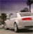 Pixelated static image of a white sedan with red taillight against a purple sky, palm tree, and dark foliage.