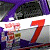 Animated sequence of a purple and white race car with red number 7, showing front view transitioning to side view against white background.