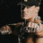 Pixelated image of a person in a cap and dark clothing holding a microphone, with text displaying 'John Cena' and 'Is HOTT!!!!!' on blue and gray backgrounds