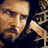 Pixelated static image of a person with light skin tone, dark hair, and visible facial features including eyes, nose, and mouth against a dark background.