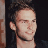Pixelated image of a person with short dark hair and light skin, wearing a black top against a dark background on the left side; green text reading 'Original Icons .com' appears on the right.