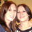 Two people with brown hair smiling closely together against a light background.