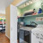 Pixelated static image showing a partial view of a room with a sink, faucet, and countertop under a window with greenery outside.
