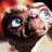 Animated sequence of a character with large blue eyes and wrinkled skin, showing subtle head movement against a blurred background.