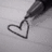A grayscale pixelated heart outline drawn with a thick pen stroke on a light gray background.