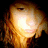 A pixelated image of a bright, glowing light source with warm orange and yellow tones radiating outward against a dark background.