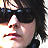 Pixelated close-up of a person with dark hair and sunglasses, mouth open in profile view against white background.